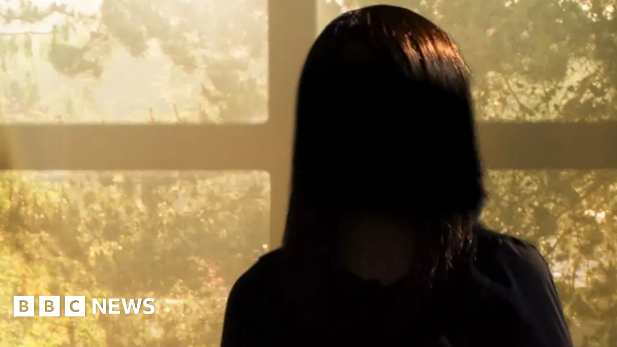 A young woman with brown hair which is blonde when it touches her shoulders holds up a number of Stanley cups and has a quizzical look on her face.