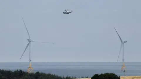 Reuters A helicopter in between two offshore wind turbines