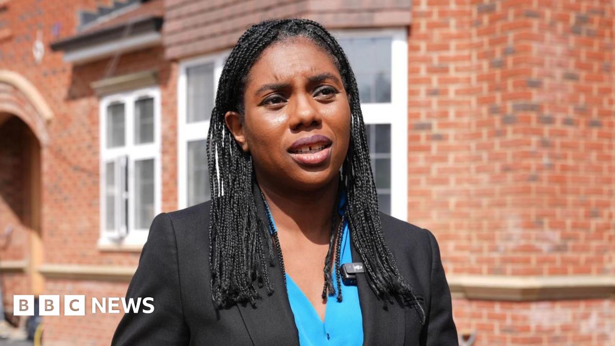 Conservative Party Leader Kemi Badenoch, wearing a blue shirt and black jacket, speaks at a London housing project.