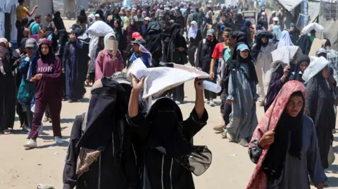 Reuters Palestinian women and girls seek aid supplies from a distribution site in southern Gaza run by the US- and Israel-backed Gaza Humanitarian Foundation (GHF), near Rafah, in the southern Gaza Strip (24 July 2025)
