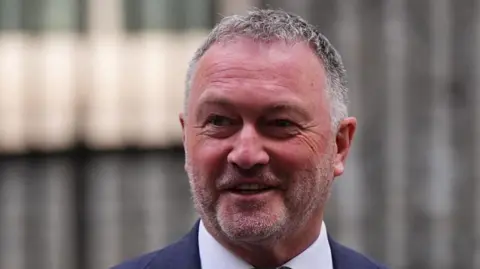PA Media Environment Secretary Steve Reed. He is smiling and wearing a navy blue suit jacket with a white collared shirt