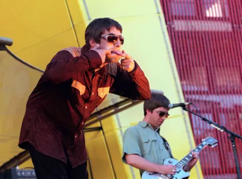 Getty Images Liam Gallagher sticks his tongue out during an Oasis show in San Francisco, 1997