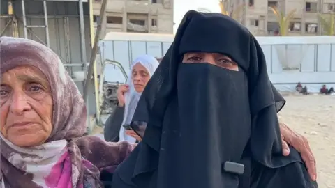 Khawla Sheikh al-Eid (R), the sister of Mary Sheikh al-Eid speaks to the BBC outside Nasser Hospital, in Khan Younis, southern Gaza (25 July 2025)