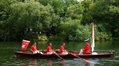 Reuters Swan upper sail up the Thames in a boat