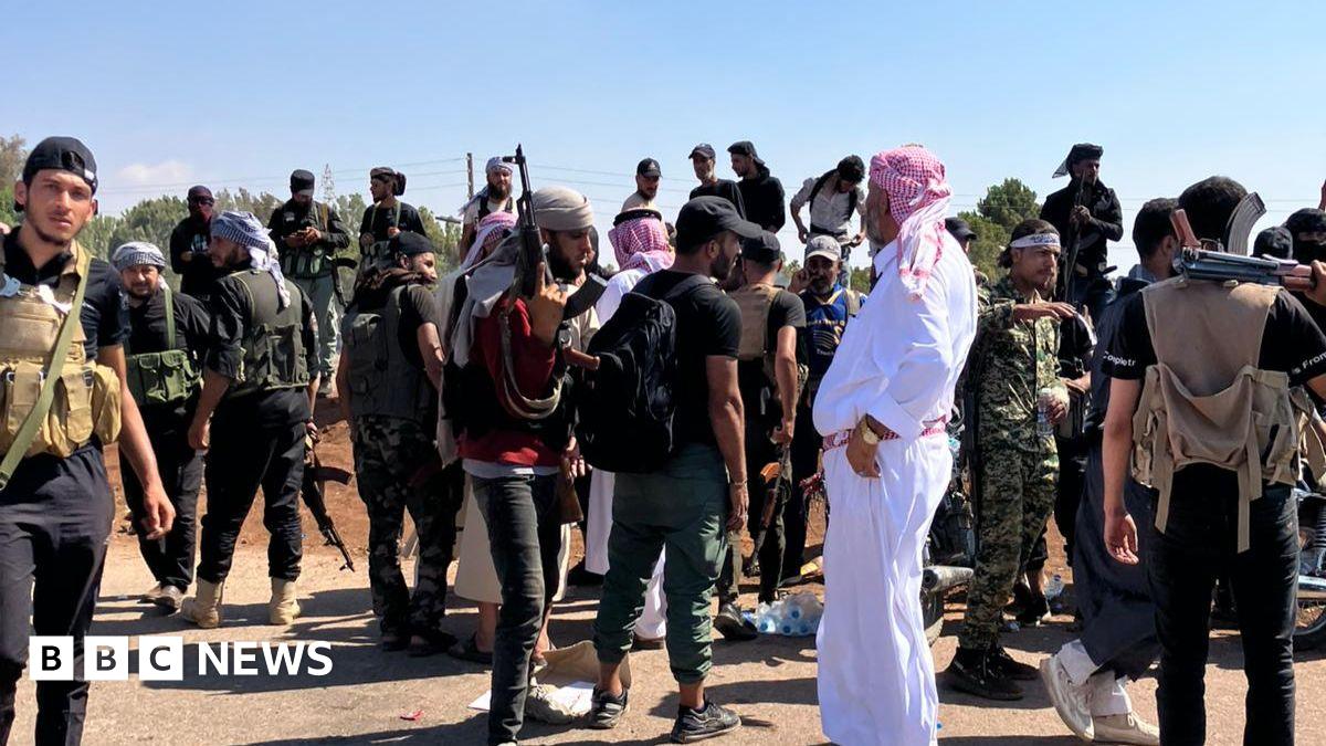 armed security forces on a berm across a road