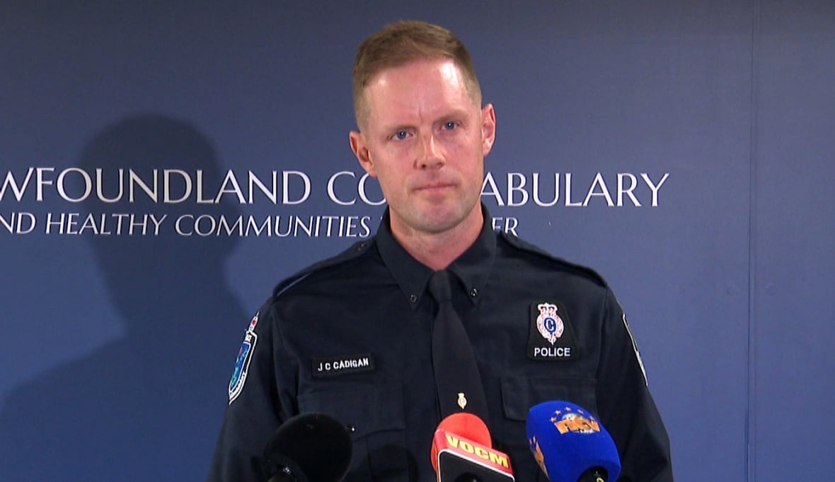 Police officer standing at podium with mics