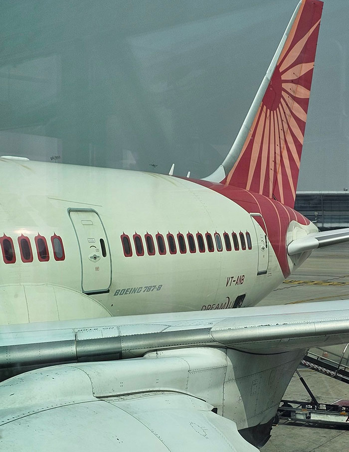 Side view of an Air India Boeing 787-8 airplane parked at the airport, highlighting Air India pilot and crash context.