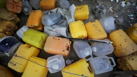 Reuters Abandoned jerrycans at the site of an Israeli strike that killed 10 Palestinians, including six children, who were queueing at a water distribution point, in Nuseirat refugee camp, central Gaza (13 July 2025)