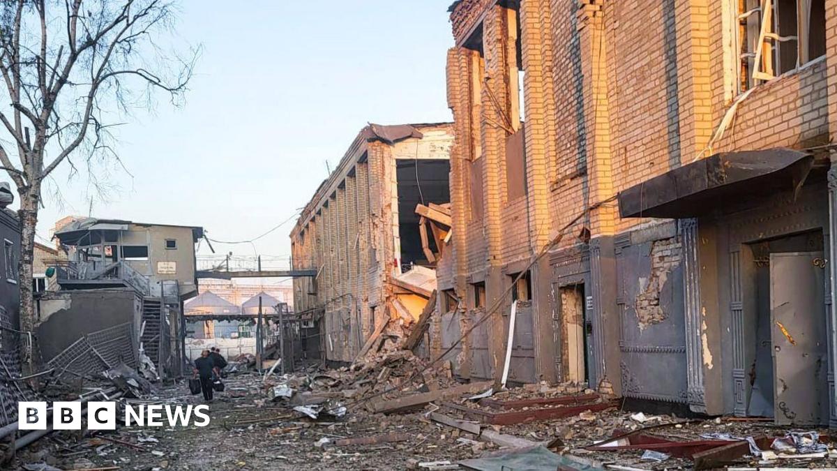 The photo shows the main prison building to the right, clad in bricks with its windows blasted out and the surrounding area all over the ground covered in debris and shrapnel