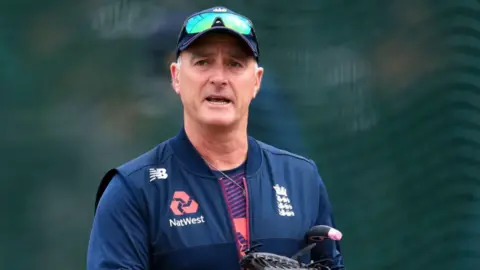 PA Media An image of former England and Surrey cricketer Graham Thorpe. He is wearing a new balance gilet with England and Natwest emblems. He is wearing a cap and sunglasses.