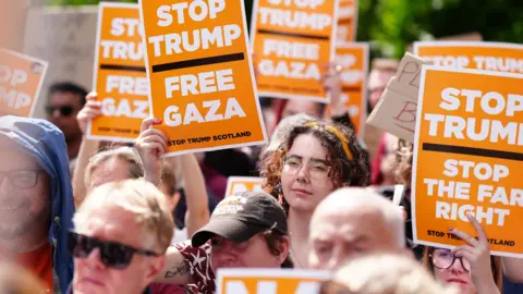 PA Media A crowd of anti-Trump protesters with orange signs bearing slogans including "Stop Trump Free Gaza"