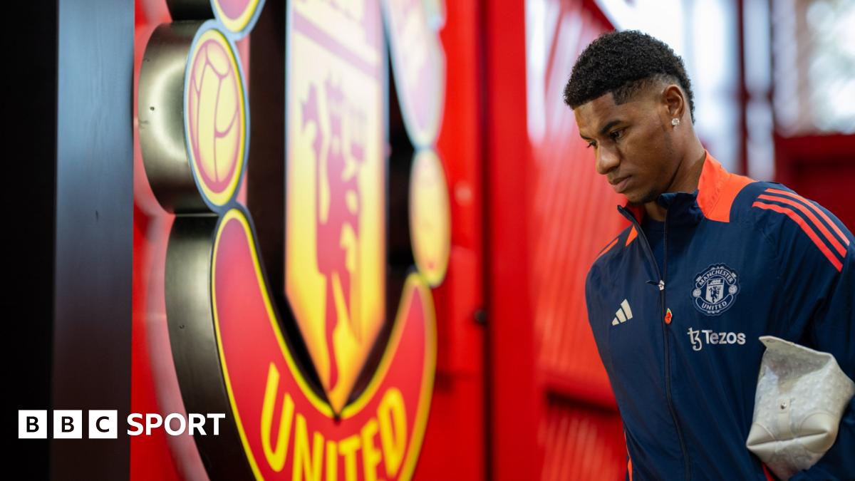Marcus Rashford pictured in Manchester United tracksuit with a washbag under his arm