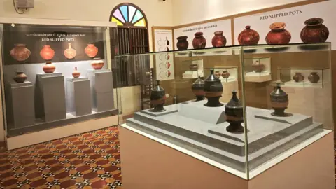 Red and black pottery excavated from the site has been placed in glass display box at the Keeladi Museum, Tamil Nadu