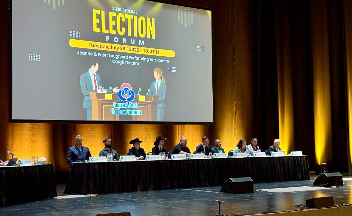 Ten people seated a long table. A large screen behind them says 'election forum.'