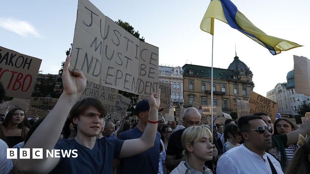 A young man holds a placard reading "Justice must be independent" during a protest in Lviv