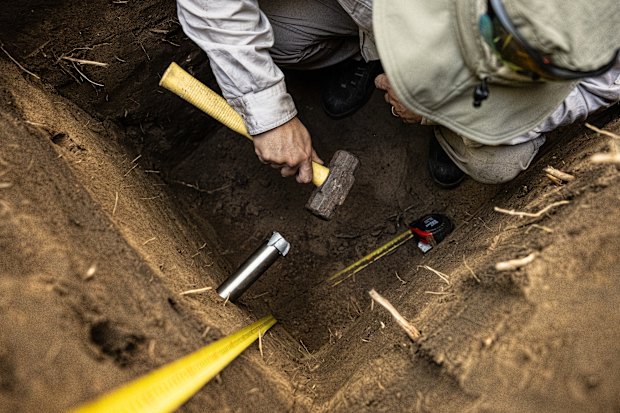 Dr Daryl Lam from Water Technology takes a sediment sample using a stainless-steel tube on the banks of the Nepean.