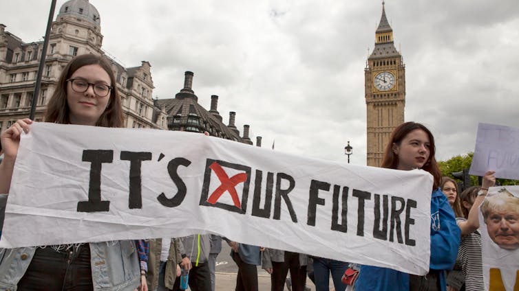 Two young people holding up a banner reading 'it's our future'.