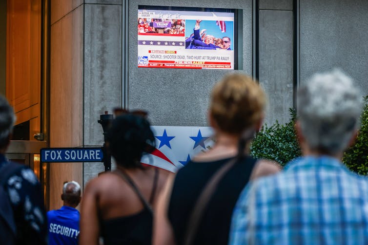 A crowd gathers in front of the Fox News building to watch a broadcast of Donald Trump.