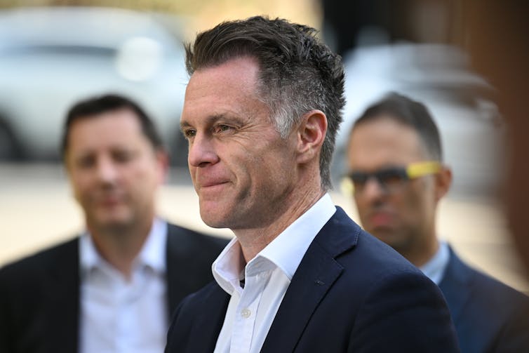 The profile of Chris Minns smiling at a press conference.