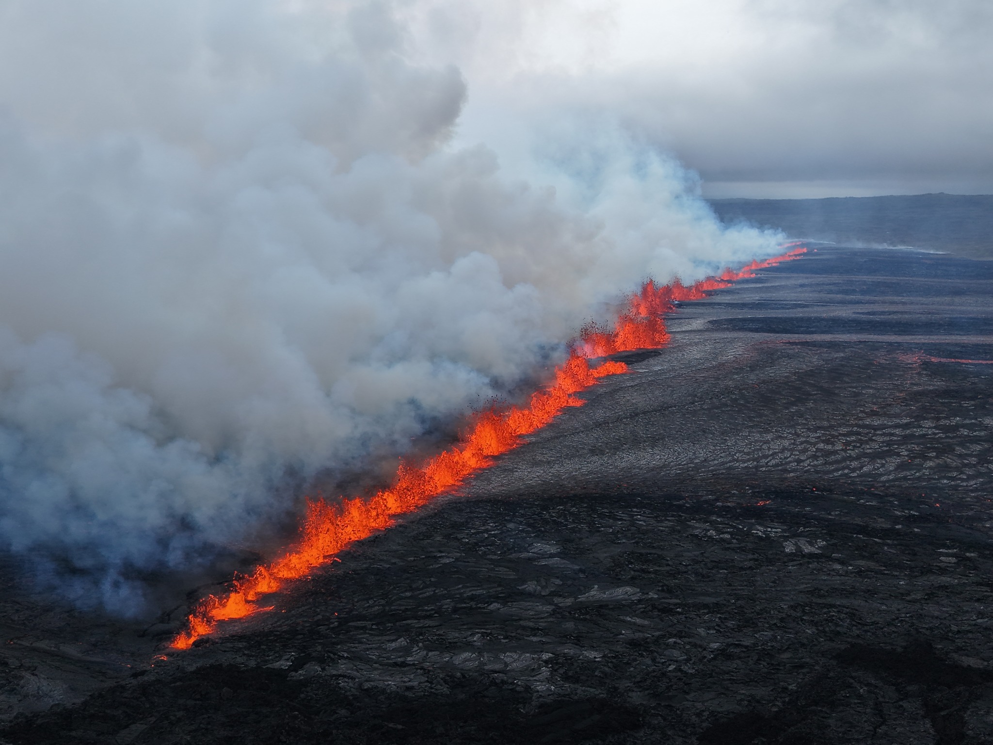 An aerial photograph of lava erupting from the Sundhnúkur crater row fissure.