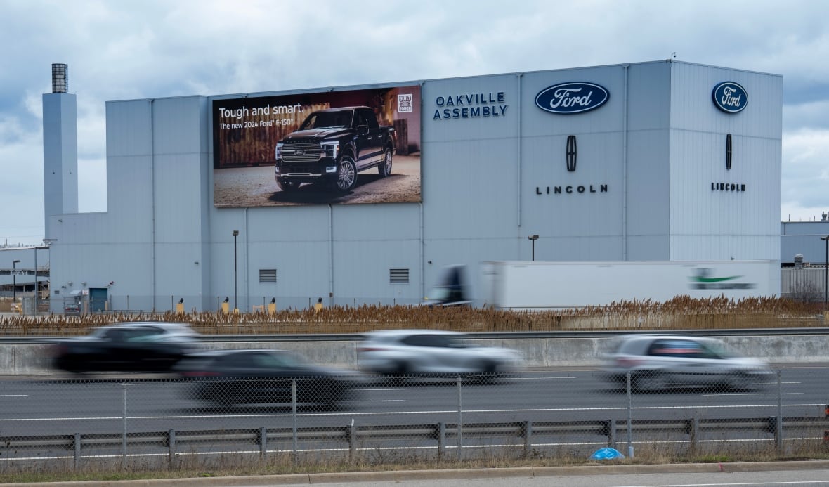 Cars zoom past the Ford Oakvielle Assembly plant in Oakville