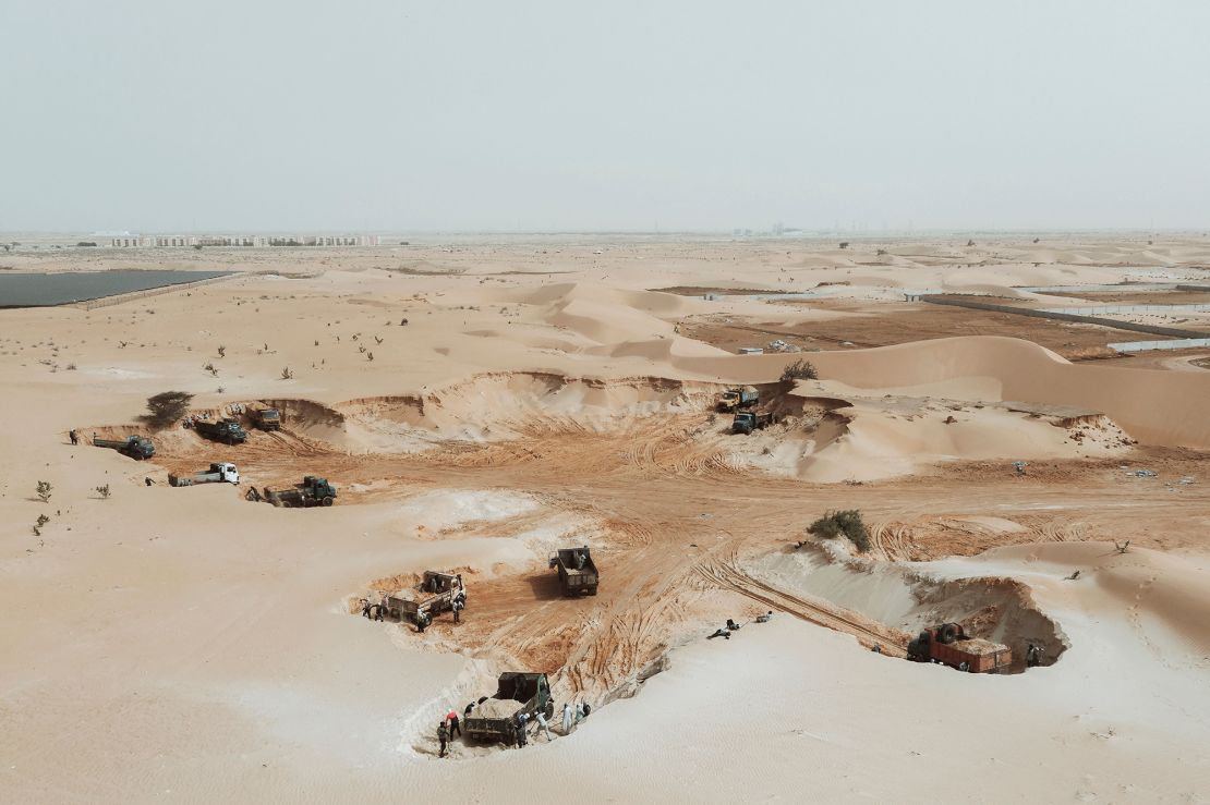An aerial view show trucks loading sand from a quarry on the outskirts of Nouakchott, Mauritania, on March 14, 2023.