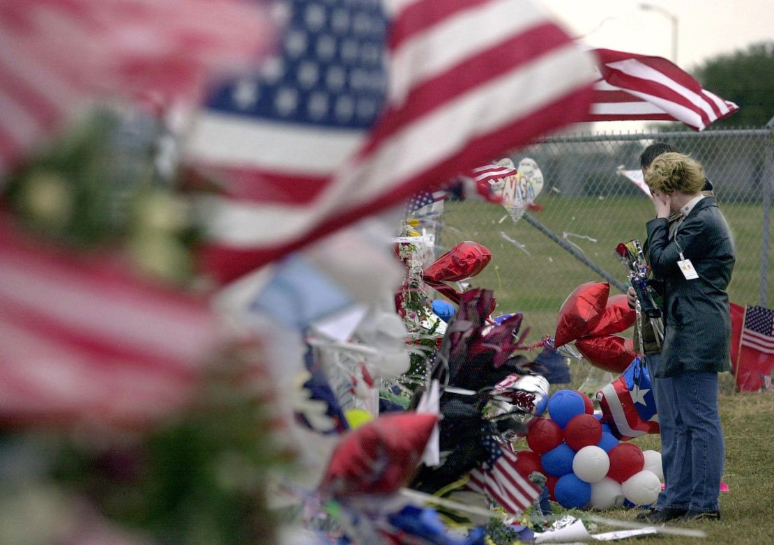 NASA worker Nicole Smith wipes a tear from her face as she visits a makeshift memorial for the seven-person Columbia crew at one of the gates of the Johnson Space Center in Houston on February 7, 2003.