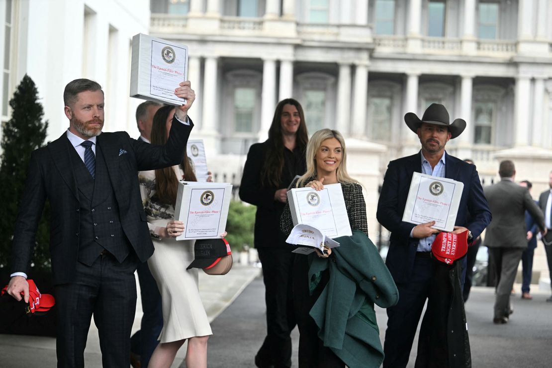 (From L) Political commentator Rogan O'Handley, aka DC Draino, TikToker Chaya Raichik, US conservative activist Scott Presler, commentator Liz Wheeler and US conservative political commentator Chad Prather carry binders bearing the seal of the US Justice Department reading 