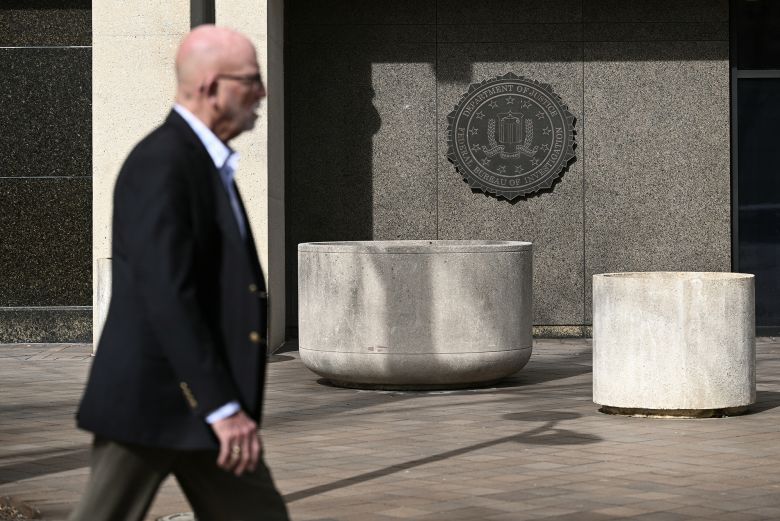 A man walks past the FBI seal on the outside of the J. Edgar Hoover building in Washington.