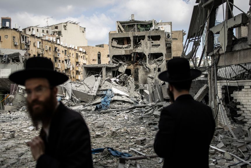 Ultra-Orthodox Jewish men inspect the damage at the site of an Iranian missile strike in Bnei Brak, east of Tel Aviv, on June 16, 2025. Iran unleashed a barrage of missile strikes on Israeli cities after Israel struck military targets deep inside Iran.