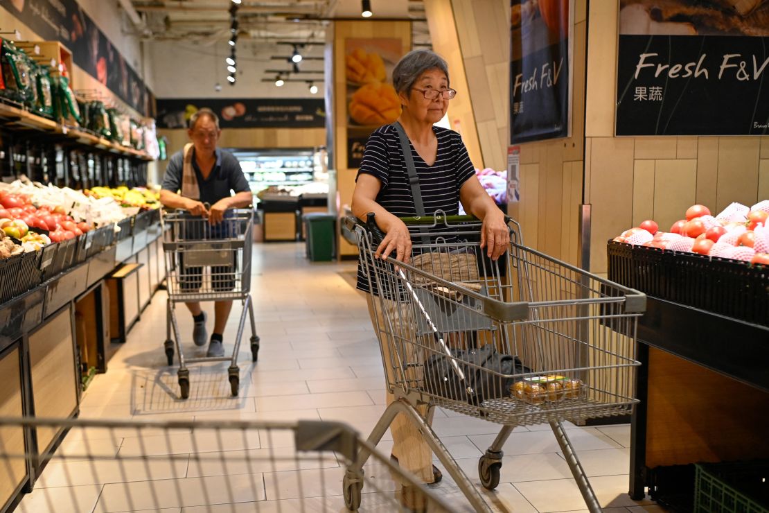 Customers push shopping carts at a supermarket in Beijing on July 9, 2025.