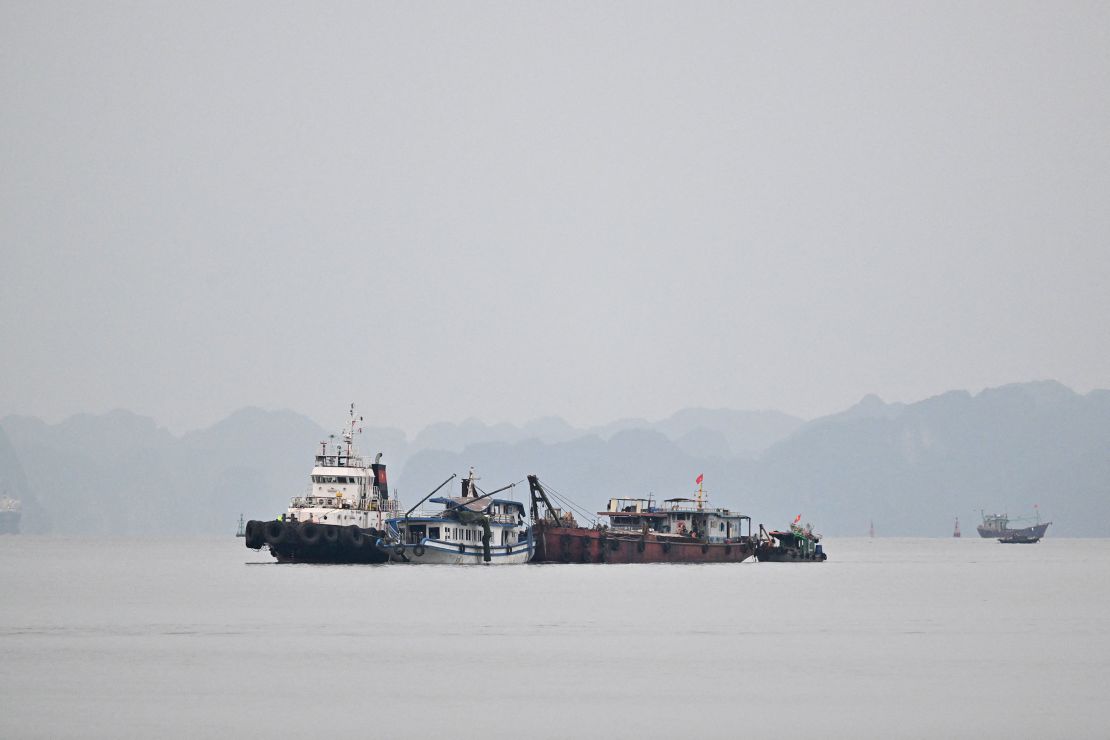 The capsized tourist boat is seen being towed back to the port on Sunday after sustaining extensive damage.