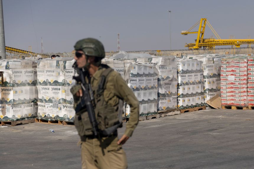 An Israeli soldier stands next to aid packages on the Palestinian side of the Kerem Shalom Crossing Point on July 24. The Israel Defense Forces showed the area to the press and reviewed this photograph prior to publication by Getty Images.