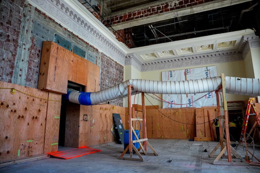 Original detail work along the ceiling is visible in the main two-story board room.