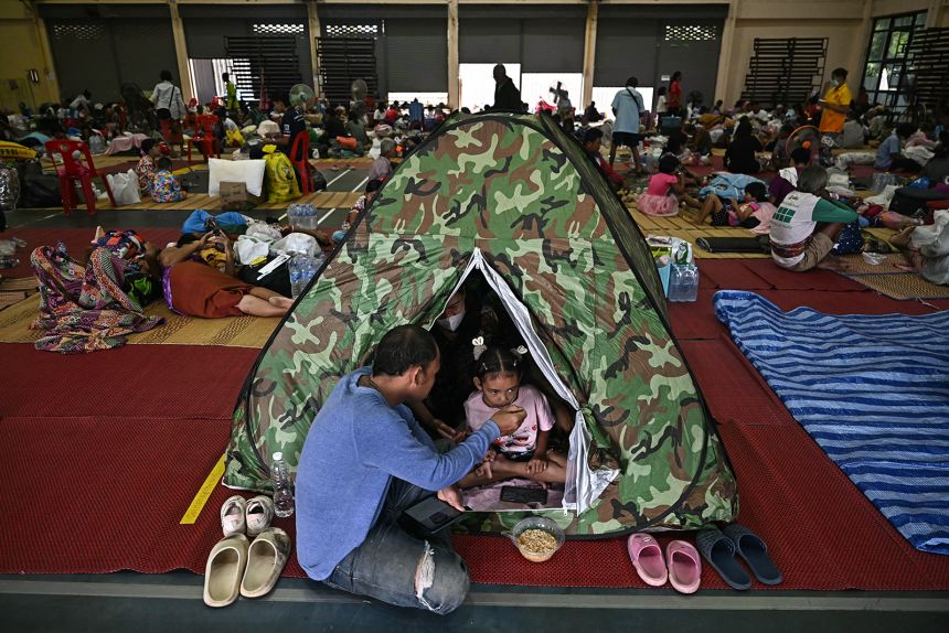 Thai evacuees eat breakfast as they take shelter in a gymnasium on the grounds of Surindra Rajabhat University in the border province of Surin on July 25.
