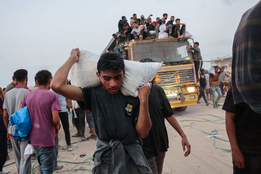 Palestinians carry aid parcels west of Beit Lahia in Gaza on July 29.