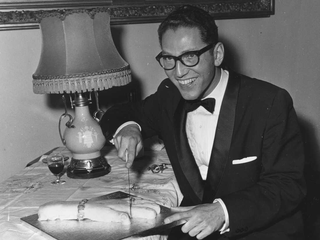 Tom Lehrer cutting a cake backstage at the Palace Theatre in London in 1959.