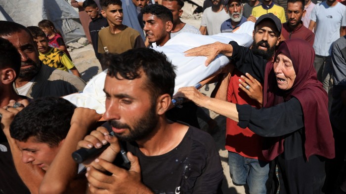 Mourners carry a body as they attend the funeral of Palestinians killed in overnight Israeli air strikes, according to medics, in Gaza