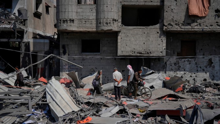 Palestinians inspect the wreckage of a petrol station destroyed in an Israeli air strike in Deir al-Balah earlier this month
