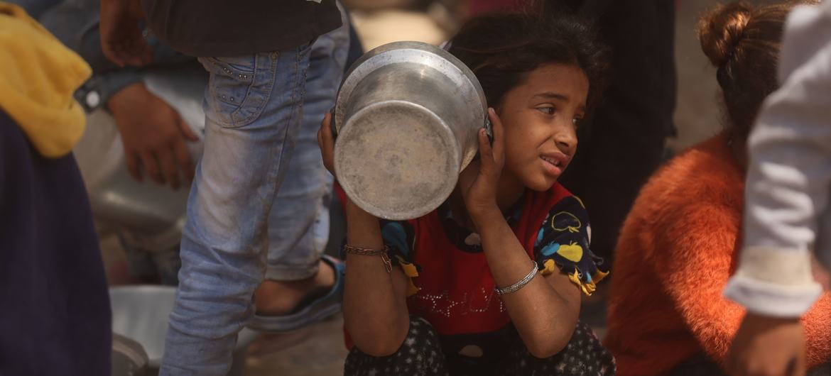 A child waits for food in Gaza.