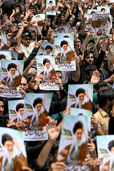 Shiite Muslim mourners hold portraits of Iran's Supreme leader Ayatollah Ali Khamenei during a religious procession held to mark Ashura, on the tenth day of the Islamic holy month of Muharram in Karachi on July 6, 2025