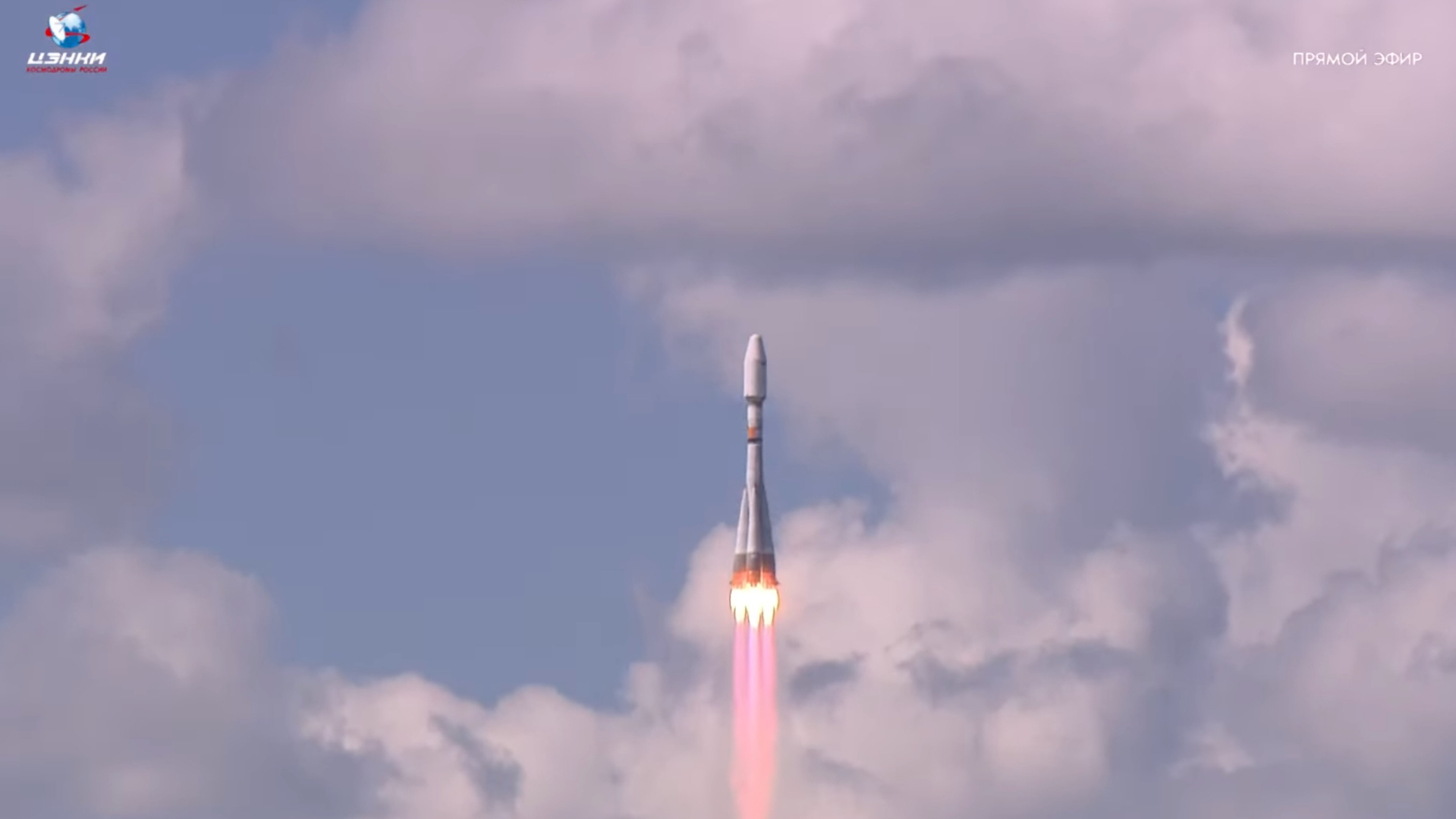 a white rocket climbs into a cloudy blue sky