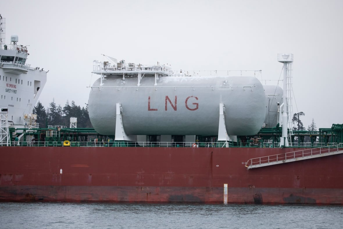 A large tank with the words 'LNG' along its side is seen on a ship.