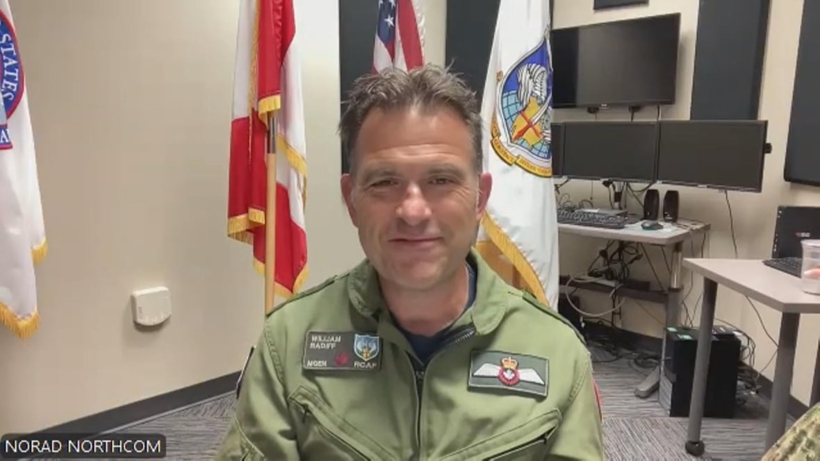 A man in uniform smiles during a Zoom meeting