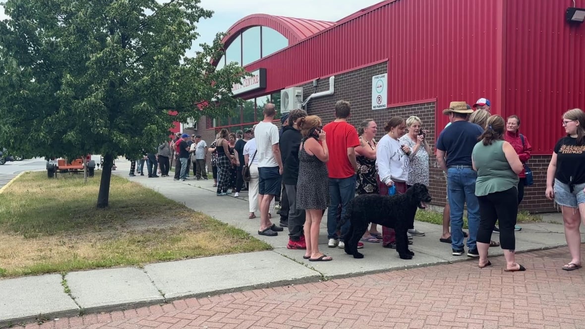 group of people lined up outside red building