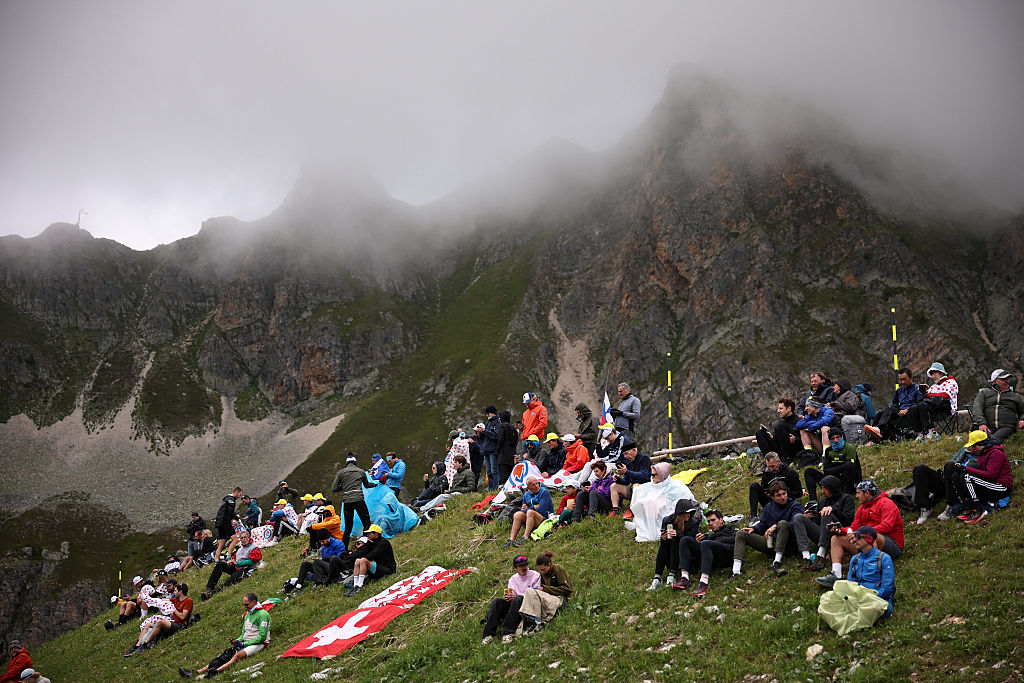 Spectators gather near the finish line area at the summit of Col de la Loze, under low cloud cover, during the 18th stage of the 112th edition of the Tour de France cycling race, 171.5 km between Vif and Courchevel Col de la Loze, in the Alps, southeastern France, on July 24, 2025. (Photo by Anne-Christine POUJOULAT / AFP)