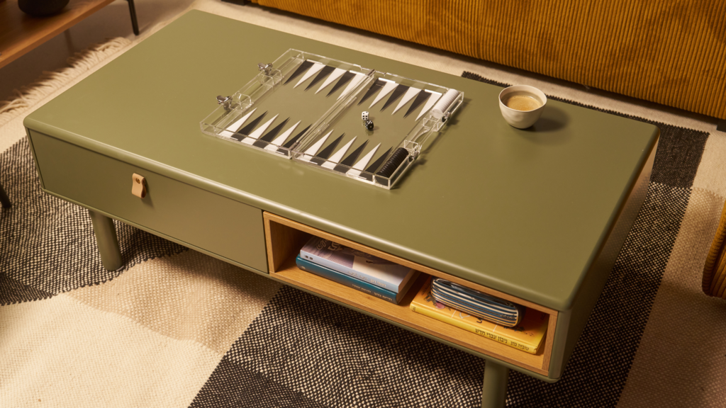 שולחן סלון ירוק דגם NEST של חברת נאפו ועליה שש-בש שקוף שנרכש בלונדון