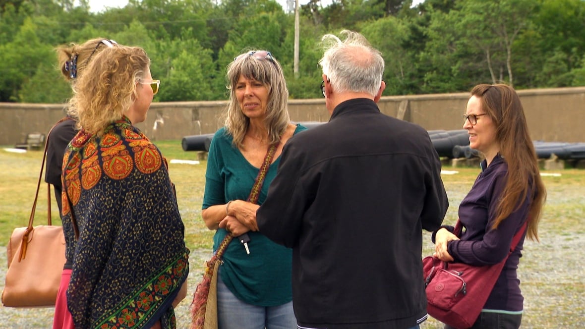 A group of residents stand outside at the historic site. 