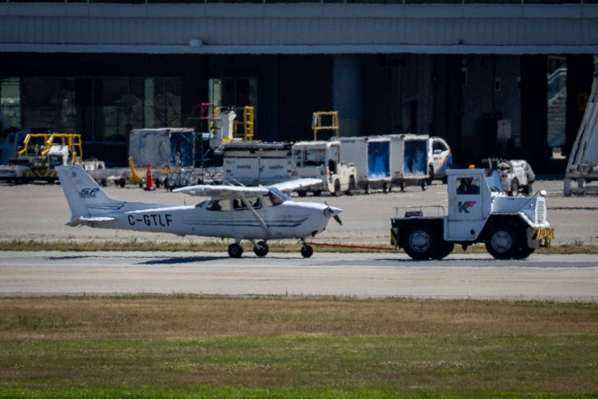 A small plane is seen with a truck in front of it.