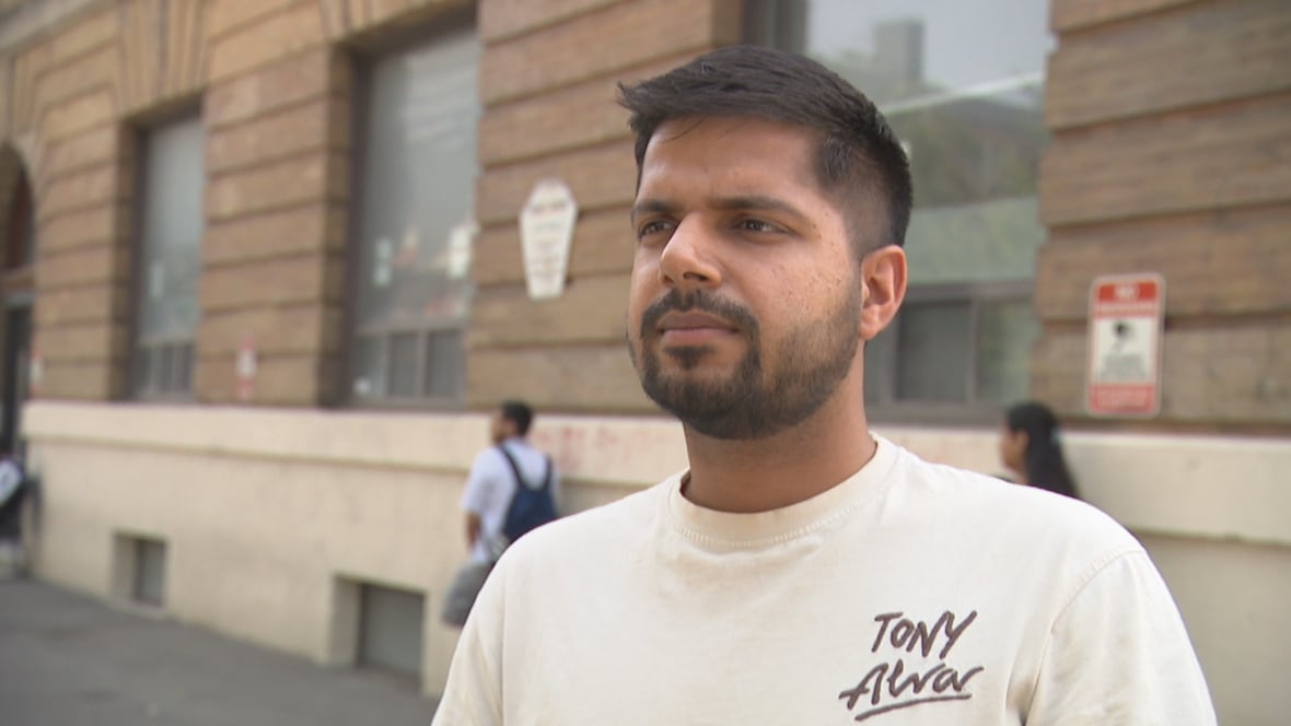 A young man in the sunshine speaks to a camera. 